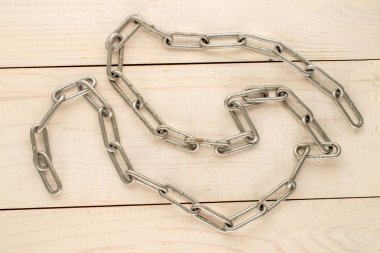 Ahşap bir masada metal bir zincir, yakın plan, üst manzara..