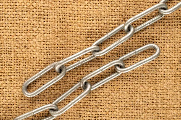 Jüt kumaş üzerine metal bir zincir parçası, makro, üst manzara..
