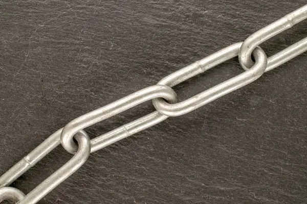 Tahta bir taşın üzerinde metal bir zincir, makro, üst görünüm.