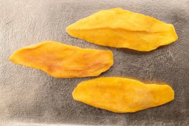 Metal bir tepside kurutulmuş mango dilimleri, yakın plan, üst görüş..