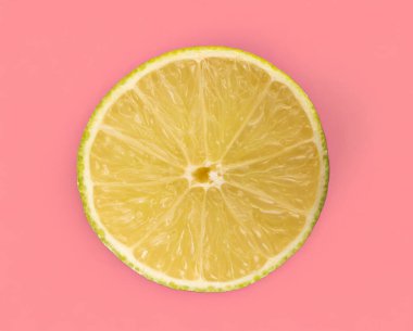 Sulu limonun yarısı pembe arka planda, yakın planda, üst tarafta izole edilmiş..