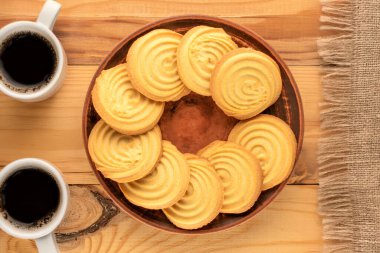 Ahşap bir masanın üzerinde mutfak aletleri olan kurabiyeler, yakın plan, üst manzara..