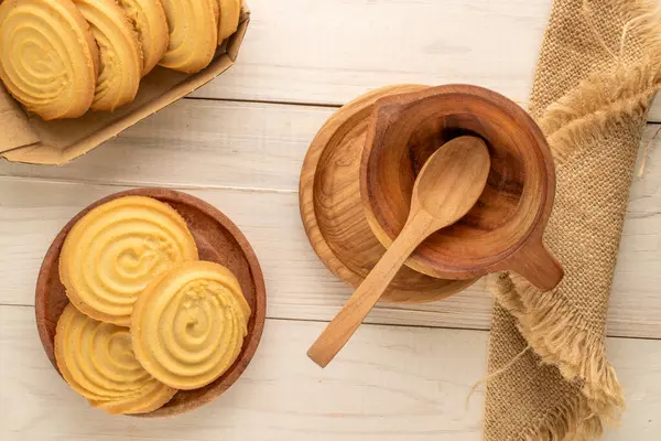 Ahşap bir masanın üzerinde mutfak aletleri olan kurabiyeler, yakın plan, üst manzara..