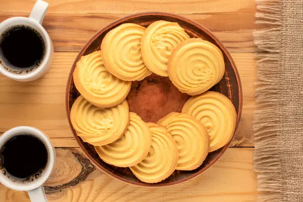 Ahşap bir masanın üzerinde mutfak aletleri olan kurabiyeler, yakın plan, üst manzara..