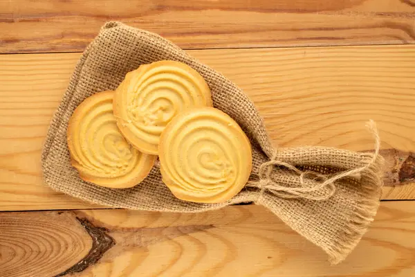 Ahşap bir masanın üzerinde mutfak aletleri olan kurabiyeler, yakın plan, üst manzara..