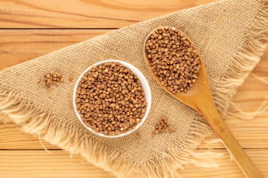 Ahşap bir masada mutfak gereçleri olan çiğ karabuğday, üst manzara, makro.