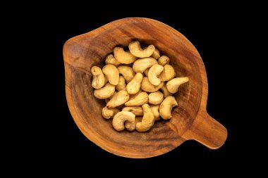 Siyah arka planda, ahşap bir fincanda organik kaju, yakın plan, üst manzara..