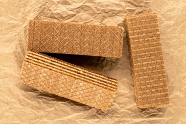 Üç tatlı waffle, makro, kraft kağıdının üstünde, üst manzara..