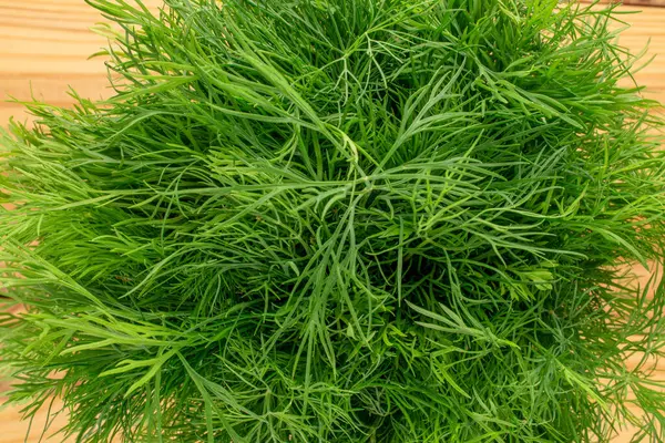 Ahşap bir masada yeşil taze dereotu, makro, üst manzara..