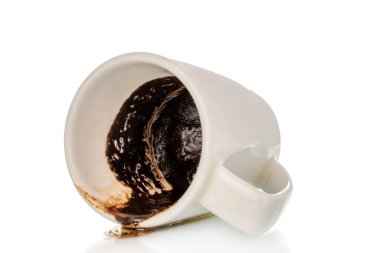 Beyaz arka planda izole edilmiş kahve kalıntısı olan bir seramik fincan, yakın plan..