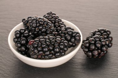 Tahta taşın üzerinde olgun böğürtlen, makro.