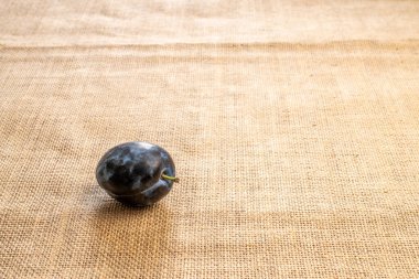 Jüt kumaş üzerinde tatlı siyah erik, makro.