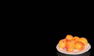 Olgun organik kayısılar siyah arka planda izole edilmiş, makro.