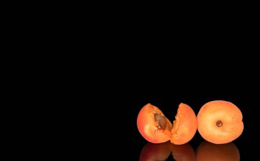 Olgun organik kayısılar siyah arka planda izole edilmiş, makro.