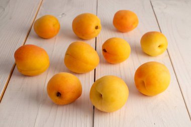 Ahşap bir masada organik olgun kayısılar, yakın plan.