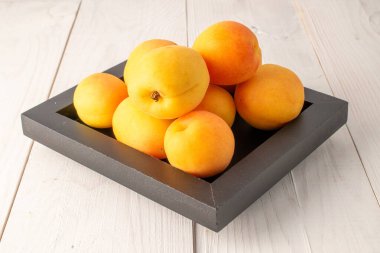 Ahşap bir masada organik olgun kayısılar, yakın plan.