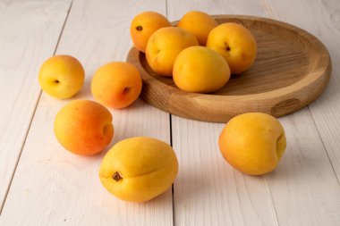 Ahşap bir masada organik olgun kayısılar, yakın plan.