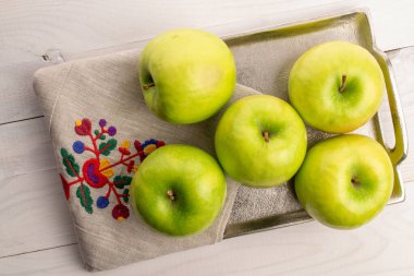 Green juicy apples on a wooden table, macro, top view.