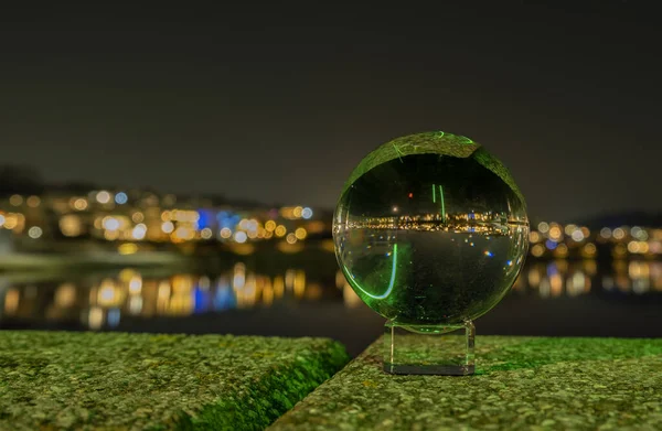 glass sphere with a green ball on the river