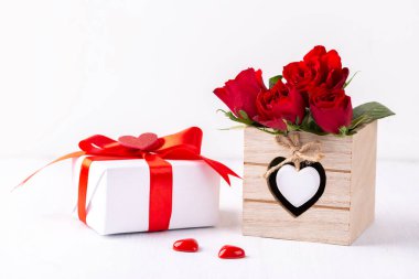 Beyaz hediye kutusu ve beyaz arka planda kırmızı güller, Sevgililer Günü kartı ya da anneler günü kartı. 