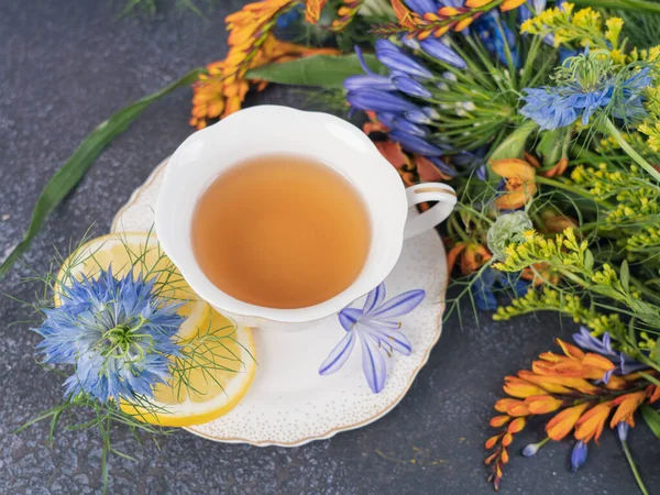 Teezeit Ein Blumenstrauß Und Eine Tasse Schwarzen Tee Mit Zitrone — Stockfoto