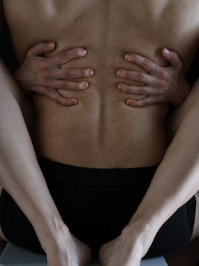 Bir erkek ve bir kadın birbirlerinin kollarında. Kadın bacakları ve kolları güçlü kaslı bir erkeği kucaklıyor. Çıplak vücutlar. Yüzü olmayan fotoğraf..