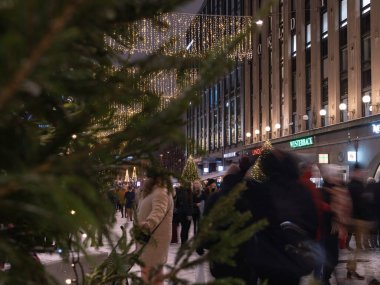 Helsinki, Finlandiya - 11 / 19 / 2022: Helsinki 'nin merkez caddelerinde Noel süslemeleri ve aydınlatma. Ön plandaki Noel ağacının dalları odak dışı..