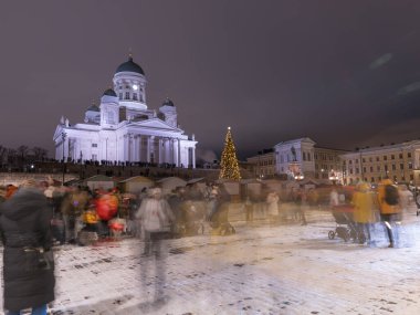 Helsinki, Finlandiya - 11 / 19 / 2022: Helsinki 'deki Senato Meydanı' nda Noel geçidi. Aziz Niklas Katedrali, bir Noel ağacı ve kalabalık. Uzun süre maruz kalan insanların hareketi.