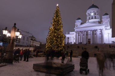 Helsinki, Finlandiya - 11 / 19 / 2022: Helsinki 'deki Senato Meydanı' nda Noel geçidi. Aziz Niklas Katedrali, bir Noel ağacı ve kalabalık. Uzun süre maruz kalan insanların hareketi.