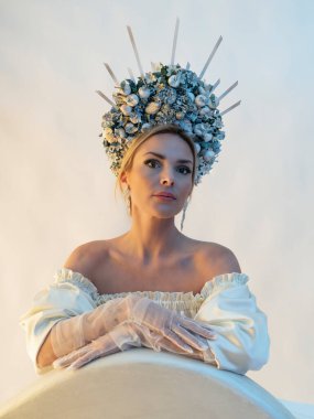 Kar Kraliçesi kılığındaki beyaz ipek elbiseli güzel bir kız. Yüzün güzelliği. Fotoğraflar stüdyoda çekildi.. 