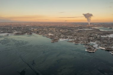 Top view of the Soukka district in Espoo from the sea. Sunset on a winter day. There is ice on the water in places. Winter landscape. Scandinavia.