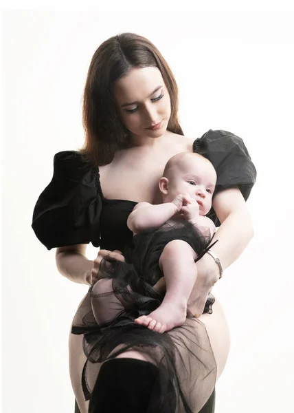 若くて現代的で美しい愛情のあるママが手を取り 彼女の愛らしい赤ちゃんにボディスーツでキスし 愛情を表現し 愛を感じ クローズアップします 幸せな母親の日 屈託のない子供時代 後見の概念 — ストック写真