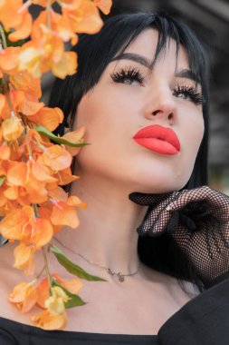 Esmer bir kadın ve siyah elbiseli kırmızı dudaklar, kafasında parlak bir eşarp. yakın plan portre