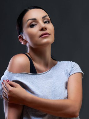 Gri bir arka planda siyah elbiseli bir kadın dansçı.