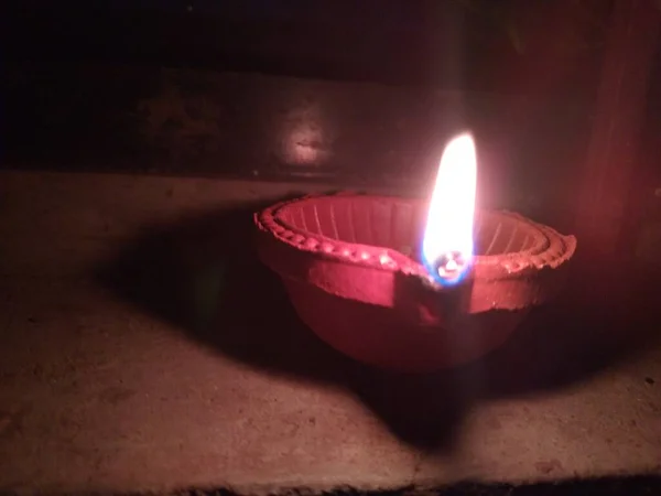 stock image Diwali lamp front view. A lamp behind a Tulsi tree at night. closeup view of Diwali lamp.