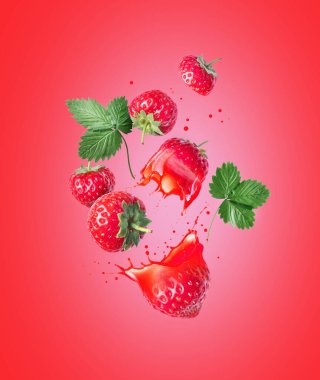 Tam ve dilimlenmiş çilek suyu kırmızı arka planda havaya sıçramış.
