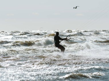 Professional rides the waves in stormy weather in the sea