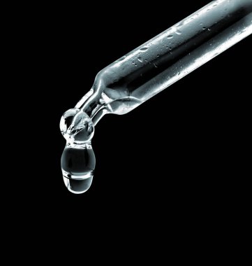 Siyah arka planda damlayan damla ile kozmetik pipeti