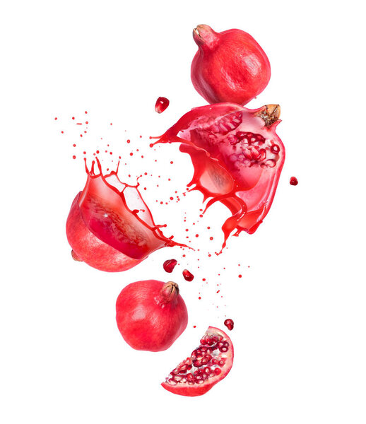 Halves of sliced pomegranate with juice splashes in the air isolated on a white background