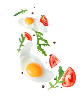 Havada domatesli ve roka soslu iki sahanda yumurta. Beyaz arka planda izole edilmiş.