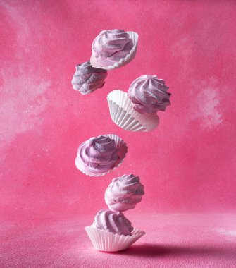 Pembe arka planda kağıt ambalajlı şekerlemeler.