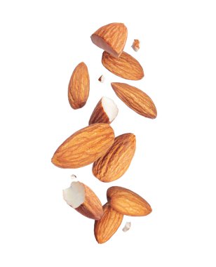 Havadaki bütün ve çatlak bademlerin yükselişi beyaz bir arkaplanda izole edilmiş.