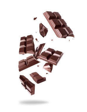 Havadaki ezilmiş siyah çikolata çubuğu beyaz arka planda izole edilmiş.