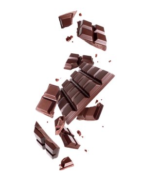 Beyaz arka planda izole edilmiş, ezilmiş siyah çikolatanın havada yükselmesi.