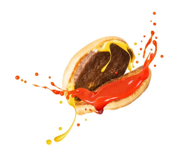 Splashes of ketchup and melted cheese flowing from a cheeseburger on a white background