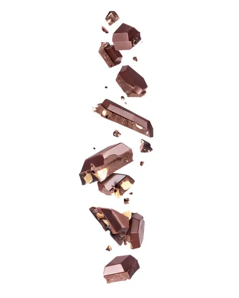 壊れたチョコレートバーと空気中のナッツが白い背景に閉じ込められた ストック画像