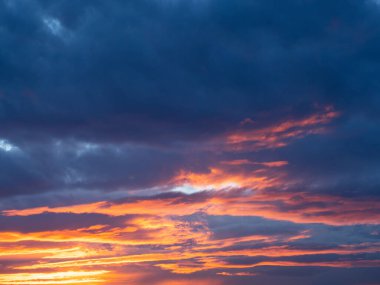 Gün batımında turuncu ve mavi renkli dramatik bulutlar. Güzel akşam gökyüzü arkaplanı