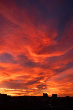 Gün batımında nefes kesen renkli gökyüzü ev siluetleriyle