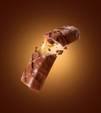 İki parçaya bölünmüş fındıklı çikolata. Kahverengi arka planda.