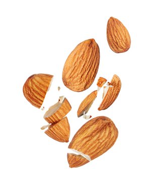 Havadaki bütün ve kırık bademlerin yükselişi beyaz arka planda izole edilmiş.